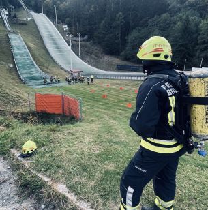 Ein Feuerwehrmann blickt mit kompletter Ausrüstung in Richtung Schanze