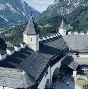 Blick vom Turm der Burg Hohenwerfen auf den Wehrgang. Im Hintergrund die Salzburger Berge